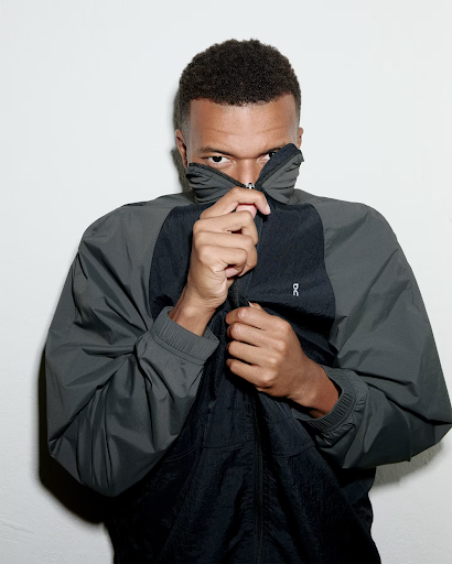 Person wearing an On jacket with the On logo visible