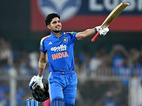 Shubman Gill celebrating a century, raising his bat