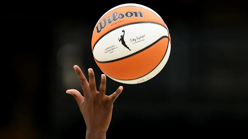 Hand reaching for a WNBA basketball